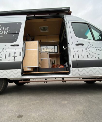 A Strait & Narrow van is open to show boxes inside.